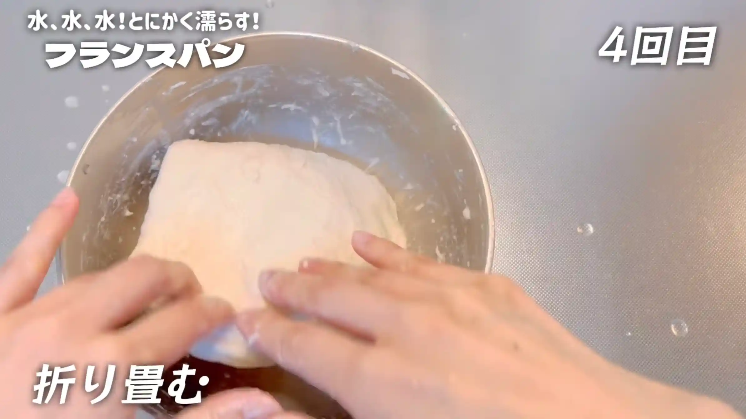 フランスパン:手を水で濡らし、生地を折りたたむ